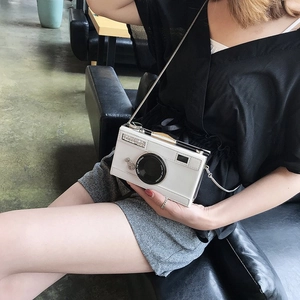 Gros plan du sac bandoulière blanc en forme d'appareil photo avec chaîne dorée