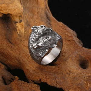Close-up of vintage steel bear head ring on rustic wood background showing metal texture