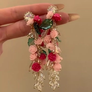 Gros plan de boucles d'oreilles pampilles avec roses en résine et perles de cristal