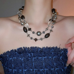 Detail of layered vintage necklace with wooden beads and crystal geometric pendants