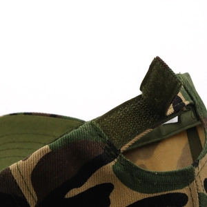 Detailed macro view of adjustable hook and loop strap on woodland camouflage baseball cap