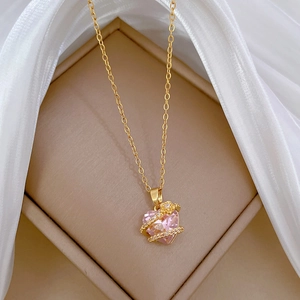 Detailed close-up of pink heart crystal necklace with sparkling accents on gold chain