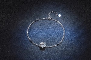 Detailed close-up of a snowflake sterling silver bracelet with a brilliant round moissanite