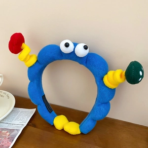 Detailaufnahme des blauen Plüsch-Monster-Haarbandes mit großen Augen und Fühlern