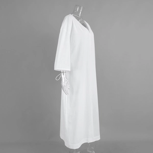 Detail view of cotton long sleeve maxi dress featuring V-neck and tied cuff accents
