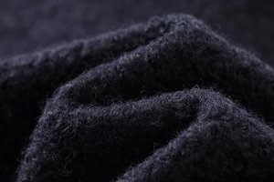Macro shot of dark navy wool blend fabric texture showing soft fibers and warm material