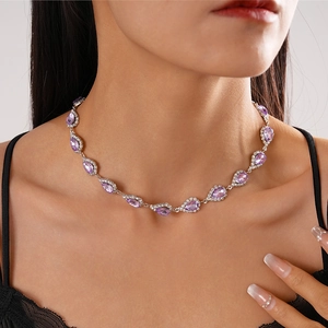 Detailed view of women's necklace featuring purple teardrop crystals and silver metal