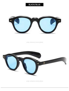 Detail of retro round sunglasses with black frames, blue lenses, and metal arrow hinges
