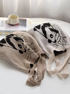 Close-up of a panda bamboo knit tote bag on a minimalist desk with books and coffee cup