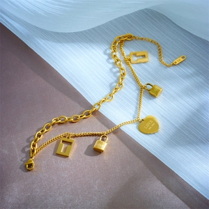 Gold double-layer chain bracelet featuring heart charms and mini lock pendants