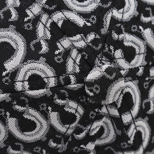 Macro detail of high-quality black and white jacquard fabric with monogram print and top button