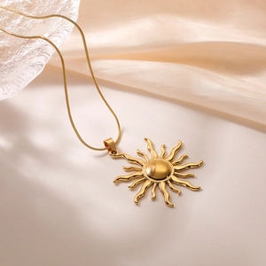 Elegant gold sunflower pendant necklace with delicate snake chain on silk background