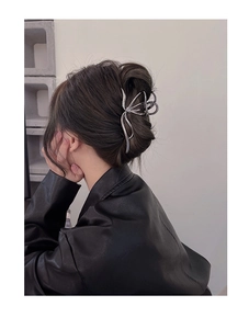 Macro detail of large silver wave hair claw clip on model with elegant updo hairstyle
