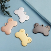 Detail of bone-shaped pet ID tags in silver, rose gold, gold, and black with paw prints