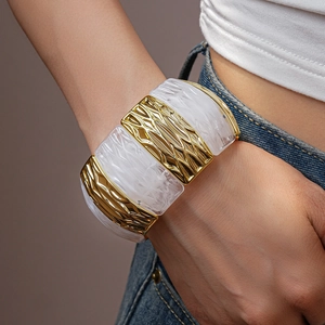 Detail of wide stretch bracelet with gold wavy metal and marble resin blocks