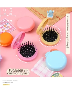 Detail of colorful macaron folding hairbrush with integrated mirror and massage bristles