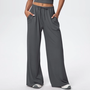 Detail of high-waisted dark grey wide-leg trousers with drawstring and soft drape texture