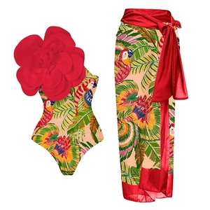 Detail of tropical macaw print swimsuit and wrap sarong with 3D red flower accent