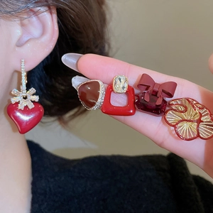 Detailed view of gold-plated red zircon earrings with heart and bow-knot designs