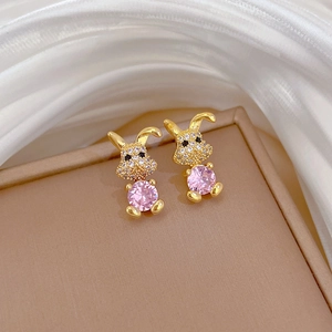 Macro shot of gold rabbit earrings with pink crystal and sparkling white zirconia