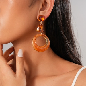 Close-up of vintage resin tortoiseshell drop earrings on model with gold metal accents