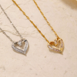 Macro view of gold and silver heart pendants with sparkling cubic zirconia detailing