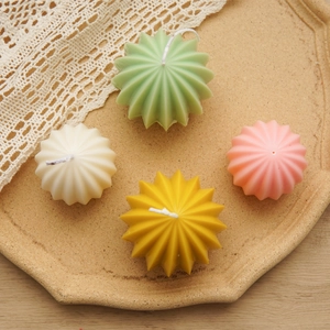 Star-shaped scented candles in pastel colors on a beige tray with decorative lace