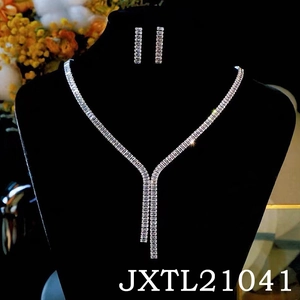 Detailed view of silver zircon tassel necklace set on a velvet jewelry display stand