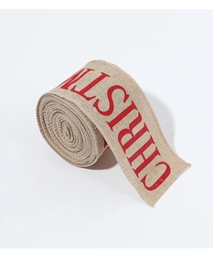 Detail of Christmas burlap ribbon with red uppercase text and visible woven texture