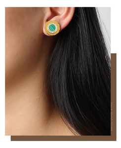 Close-up of gold titanium earring with green malachite stone and white zircon pave setting
