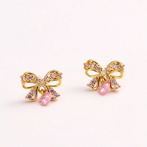 Detail of gold bow earrings with sparkling pink zircons and drop-shaped crystal pendants