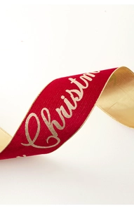 Macro view of red velvet Christmas ribbon with gold Merry Christmas lettering