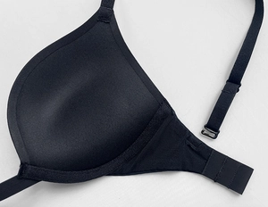 Detail of black push-up bra cup and rhinestone strap connection with textile texture