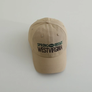 Detail of khaki cotton baseball cap showing vintage green letter embroidery and texture