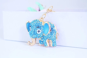 Macro detail of elephant keychain featuring blue rhinestones and gold-plated finish