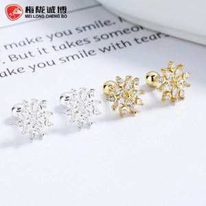 Detailed macro view of 925 sterling silver snowflake earrings in gold and silver finish