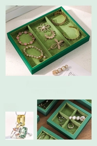 Detail of green velvet jewelry display tray showing multi-slot compartments and texture
