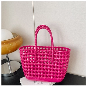 Macro view of the pink woven hollow-out texture on this durable jelly beach tote bag