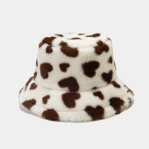 Close-up of white plush bucket hat with brown heart patterns and soft faux fur texture