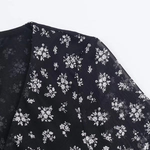 Detail of floral printed chiffon dress showing fabric texture and shoulder stitching