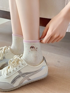 Detail of embroidered brown puppy on cream socks with pink striped elastic cuff