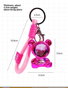 Detailed view of rose gold galaxy bear keychain with liquid sand effect and woven strap
