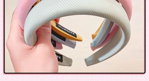 Close-up of handmade ribbed sponge headbands in pink, blue, and yellow fabric