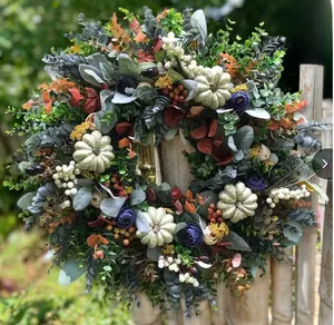 Detailed view of handmade autumn eucalyptus wreath with white pumpkins and berries