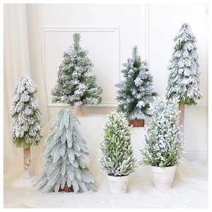 Multiple styles of mini flocked Christmas trees with cedar bases and snow effect