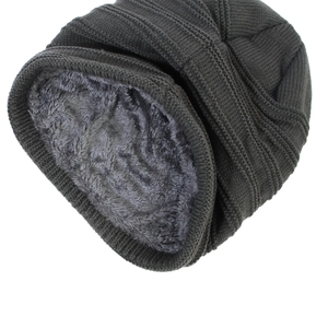 Detailed close-up of dark grey knitted hat with thick faux fur lining for winter warmth