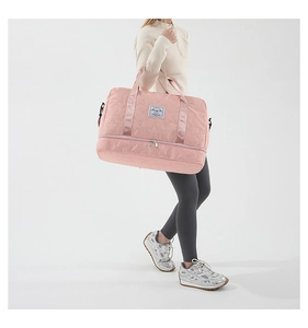 Detail of pink star-quilted travel bag featuring a bottom shoe compartment and handles