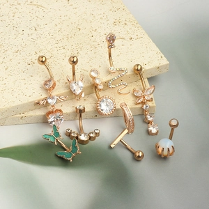 Collection of gold navel rings with cubic zirconia and butterfly designs on stone