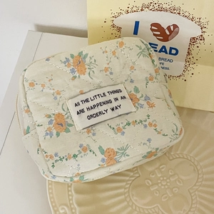 Macro shot of quilted floral fabric pouch on a decorative plate with an artistic label