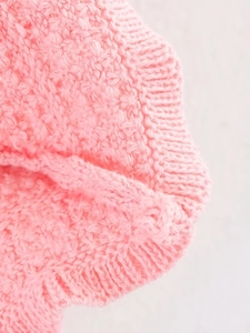 Detailed close-up of pink knit fabric showing soft texture and fine stitching craft